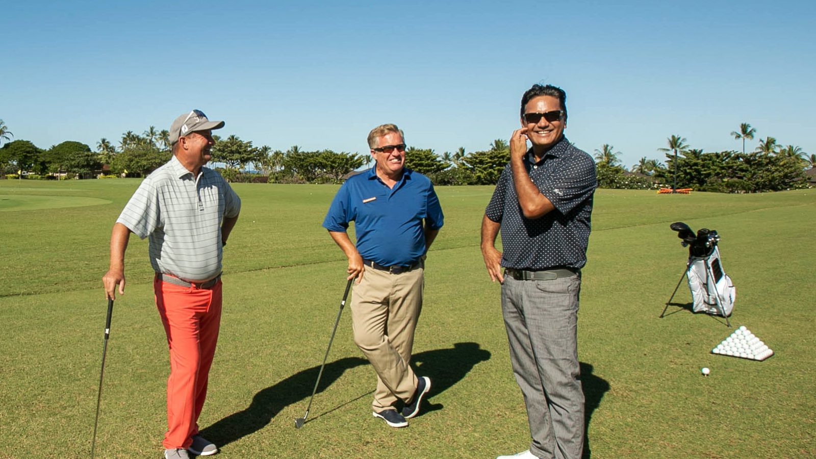 1x1 golf pros Three Golf pros standing on golf course smiling