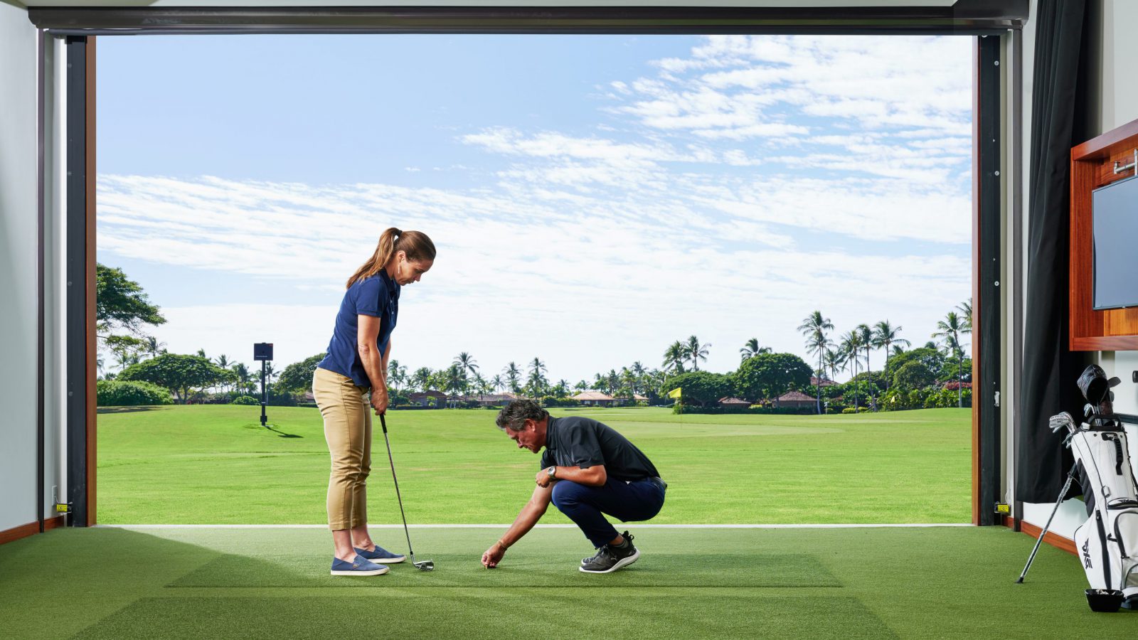golf-hale-293 An instructor places a tee on the indoor golf turf while the person taking the lesson readies her swing.